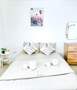 een wit bed met vier kussens erop bij The Sunset Bangsaen in Ban Rong Khoei