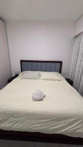 een groot wit bed met een witte handdoek erop bij Azure in Aqaba