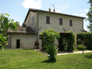 un grande edificio bianco con un cortile verde di Modern holiday home in Foligno - Loc with pool a Case Vecchie