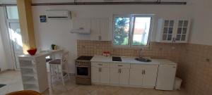 a kitchen with white cabinets and a sink and a stove at Vaso & Viktor Apartment in Kotor