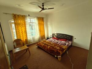 a bedroom with a bed and a fan and a chair at The Atiq Stay in Jāmb