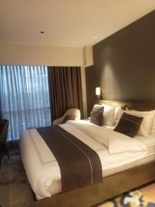 Postel nebo postele na pokoji v ubytování MADR Excellence at Novotel Manila Hotel Residence Acqua