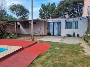 a house with a red rug in the yard at Macrigaluma Sol con seña in Barra del Chuy