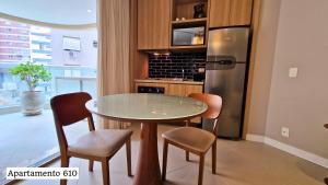 a kitchen with a table and chairs and a refrigerator at Book Santos - Apartamentos no Unique Residence in Santos