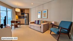 a living room with a couch and a chair at Book Santos - Apartamentos no Unique Residence in Santos
