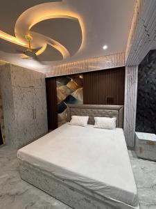 a bedroom with a large bed with a ceiling at Hotel Nav Prayag Inn in Prayagraj