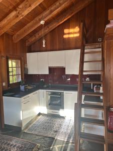 una cucina con mobili bianchi e un forno di Chalet à Savièse en bordure de forêt a Savièse