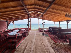 a pavilion on the beach with the ocean in the background at Baywatch Camp in Nuweiba