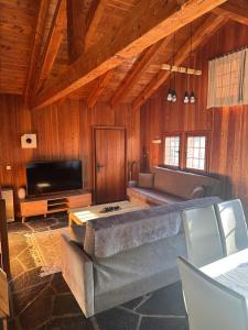 un soggiorno con un divano e una TV di Chalet à Savièse en bordure de forêt a Savièse