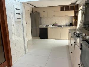 a kitchen with white tile floors and a refrigerator at Maison indépendante avec jardin in Abidjan +9 photos