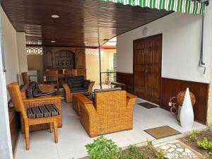 an outdoor patio with wicker chairs and a table at Maison indépendante avec jardin in Abidjan