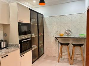 a kitchen with a counter and two bar stools at Maison indépendante avec jardin in Abidjan