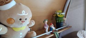 a toy teddy bear on a shelf with flowers at 노을이 아름다운 호미곶 캠핑카 in Sup'sil