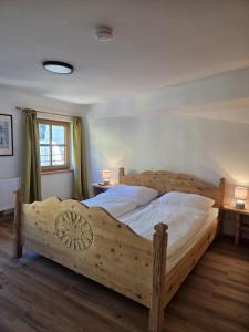 a large wooden bed in a bedroom with two tables at Resi´s Stadthaus in Kitzbühel