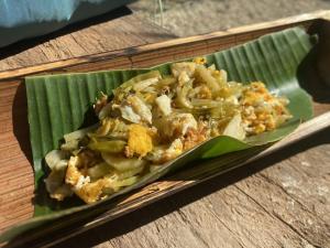 een bord voedsel op een groen bananenblad bij Amazing Mountain Camping, Bar&Grill in Ban Pang Hai