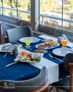 een tafel met borden met voedsel op een blauwe tafeldoek bij Zileli Suıtes in Hamidiye +75 foto's