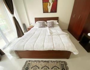 a bedroom with a large bed with white sheets and pillows at Goa stays in Anjuna