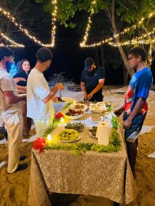 een groep mensen die rond een tafel staan met eten erop bij White Sandy Beach Dive Resort in Naviti Island