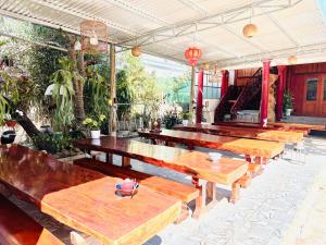 a row of wooden tables in a patio at Moc Chau Town - Homestay in Mộc Châu