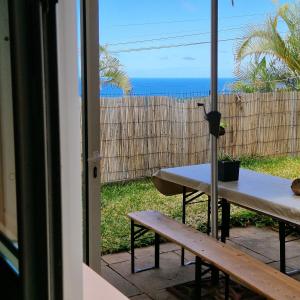 eine Terrasse mit einem Tisch und Meerblick in der Unterkunft Petit jardin suspendu in Petite Île