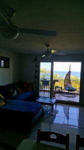 ein Wohnzimmer mit Couch und großem Fenster in der Unterkunft Petit jardin suspendu in Petite Île