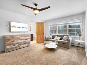 un soggiorno con un divano e un ventilatore a soffitto di The Mendon House a Killington