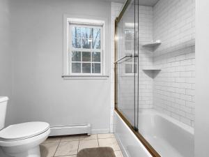 e bagno bianco con servizi igienici e vasca. di The Mendon House a Killington Altre 37 foto