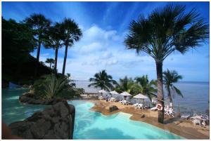 a resort with a swimming pool and palm trees and the ocean at Eagle Point Beach and Dive Resort in Mabini