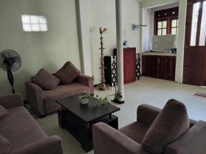 a living room with couches and a table at Foreign Home Stay in Katugastota
