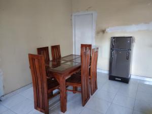 a dining room table with chairs and a refrigerator at Foreign Home Stay in Katugastota