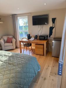 a bedroom with a bed and a desk with a television at Pine Ridge 1 in Bristol