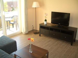 ein Wohnzimmer mit einem TV und einem Tisch mit Blumen in der Unterkunft Ferienwohnung Rerik in Rerik