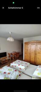 una camera con due letti, un tavolo e un lampadario a braccio di Hotel Restaurant Park Jaizinen a Mitthal