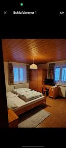 una camera da letto con un letto, una scrivania e finestre di Hotel Restaurant Park Jaizinen a Mitthal