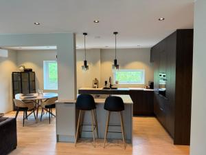 a kitchen with two bar stools and a table at Nyoppusset leilighet til leie in Isfjorden