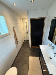 a bathroom with a toilet and a sink and a black door at Nyoppusset leilighet til leie in Isfjorden +4 photos