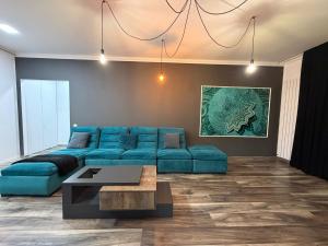 een woonkamer met een blauwe bank en een tafel bij Tampa Gardens Apartments - Adults Only in Braşov
