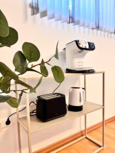 een plank met een broodrooster en een printer erop bij Flower House - Souterrain with Garden in Mölbling