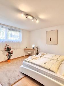 een witte slaapkamer met een groot bed in een kamer bij Flower House - Souterrain with Garden in Mölbling