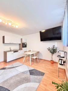 een woonkamer met een tafel en een keuken bij Flower House - Souterrain with Garden in Mölbling