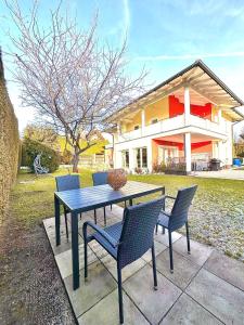 een tafel en stoelen voor een huis bij Flower House - Souterrain with Garden in Mölbling