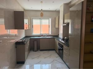 a kitchen with a sink and a stove at Licht & ruim 2-slaapkamer appartement met airco & Wifi - rustig wijk Marrakesh in Marrakesh +12 photos