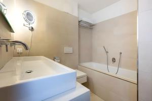 a white bathroom with a sink and a shower at Mountain Lodge Leogang-Premium Apartment, Balkon, Bergblick, Kamin, Sauna in Leogang