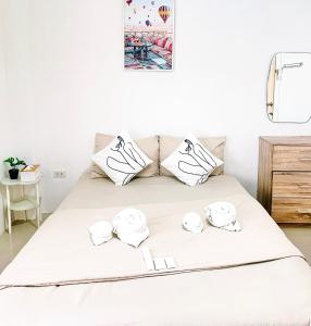 een bed met witte lakens en witte kussens bij The Sunset Bangsaen in Ban Rong Khoei