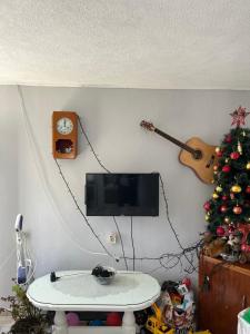a living room with a tv and a christmas tree at Guest House Fenix in Karuči