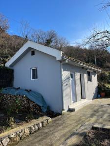 a small white garage with a driveway at Guest House Fenix in Karuči