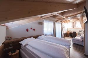 卡纳泽伊维特斯山区小屋酒店的一间卧室，里面有一张铺着白色床单的大床。 更多42张照片