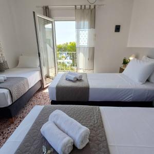 deux lits dans une chambre avec balcon dans l'établissement Kalimera Aegina, à Agia Marina