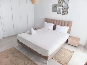 ein Schlafzimmer mit einem großen Bett mit weißer Bettwäsche in der Unterkunft Jade Luxury Apartment La Marsa in Dar el Haj Ahmed Souid