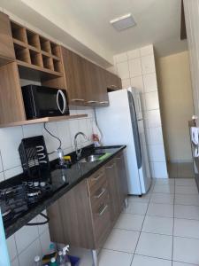 een keuken met een spoelbak en een koelkast bij Beachfront Apartment in Itanhaém